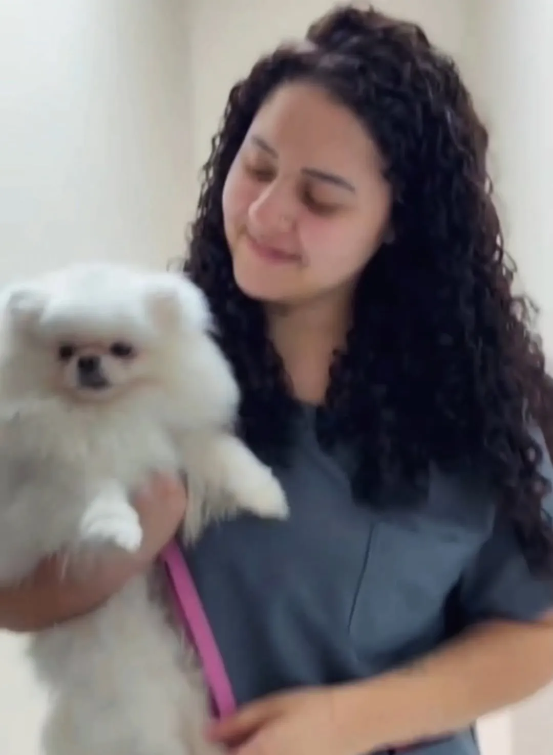 Veterinária do Real Parque segurando um lulu-da-pomerânia branco